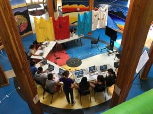 students on laptops sitting in a circle