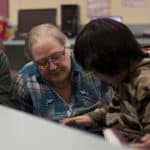 An instructor and student using a computer.