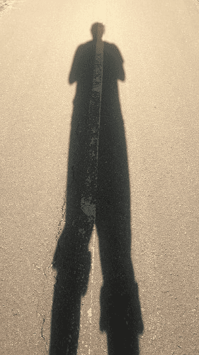 A photo of a shadow on pavement.