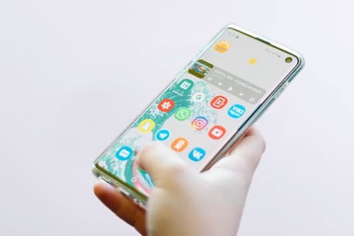 cultural sensitivity when posting online, person holding a phone with it open to its home screen