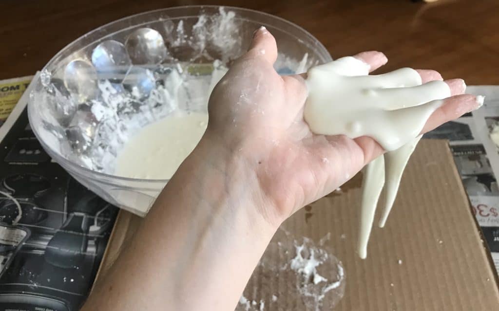 A hand holding white paste.