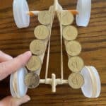 A race car made out of bottle caps, popsicle sticks, and straws.