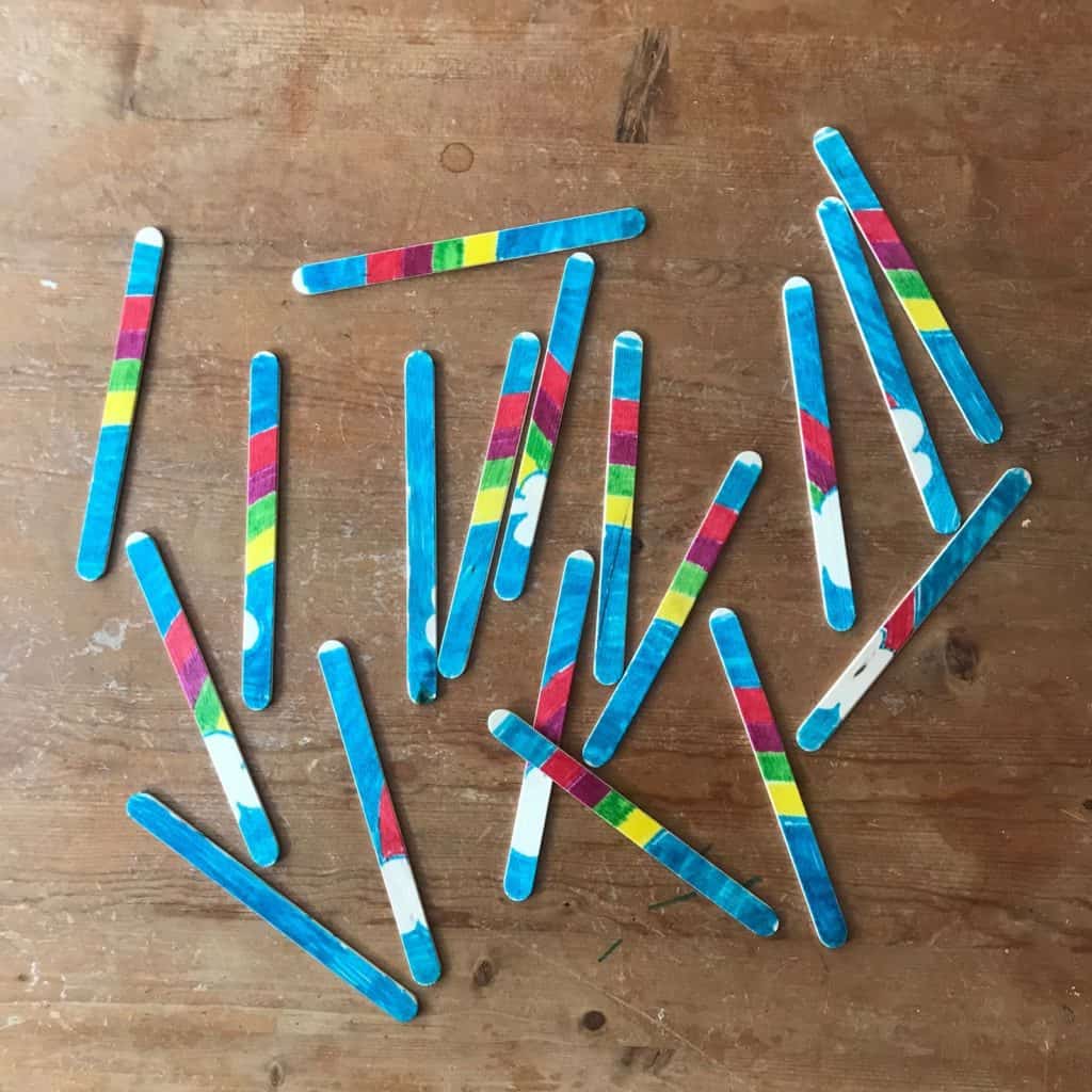 An unfinished rainbow puzzle made with popsicle sticks.