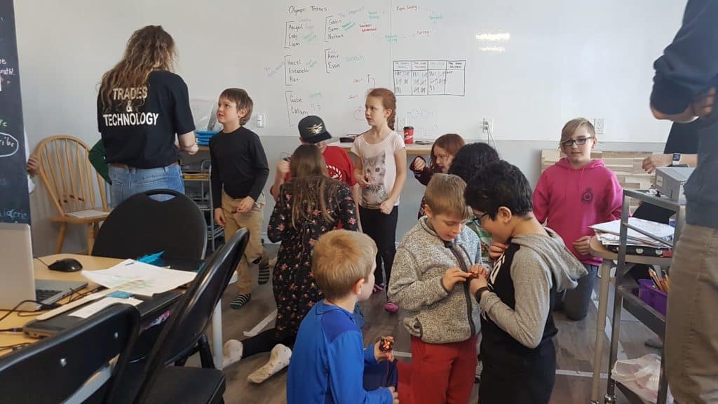 Students gathered in the Lindsay Makerspace looking down at their projects.