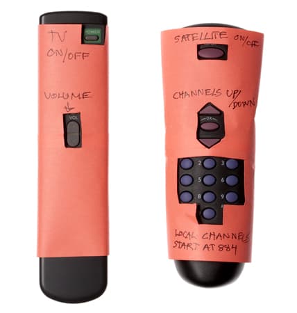 A simplified remote control with buttons that aren't required covered up.