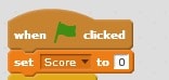A group of Scratch blocks that set the score variable to 0 when the green flag is clicked.
