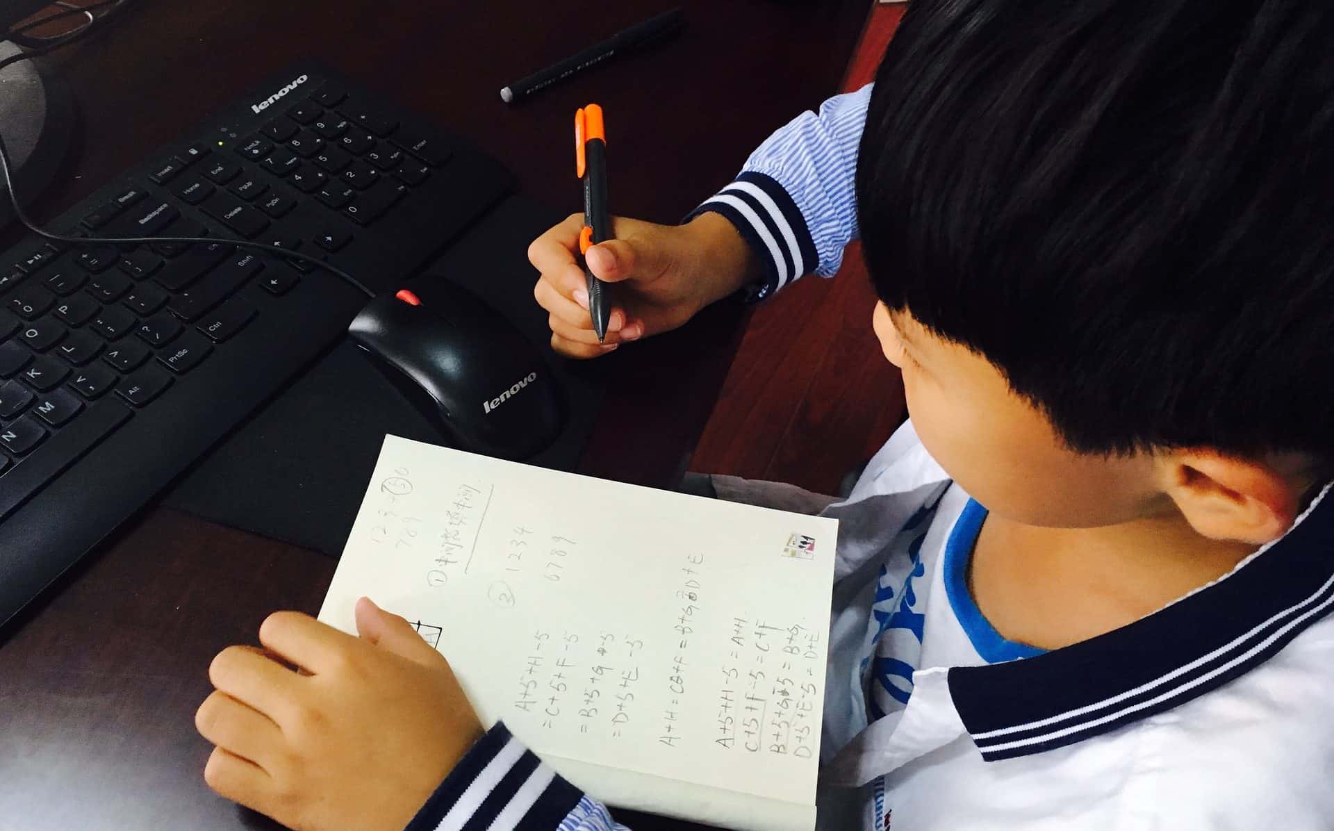 A child writing stuff down on a piece of paper.