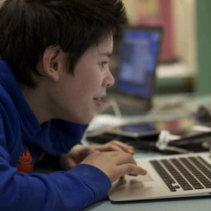 A child using a computer for a lesson.