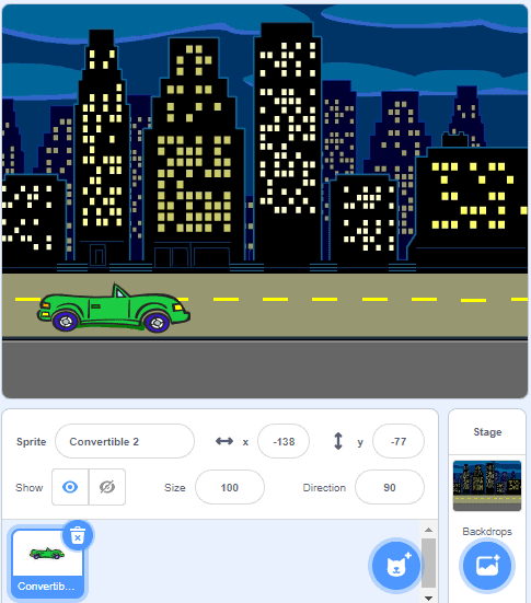 The top half of the scratch backdrop is a photo of a green car on a highway, with buildings illuminated in the background. The bottom half is buttons you click to change your backdrop and your scratch character.