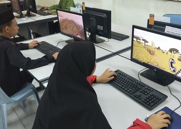 Students playing Minecraft on a computer.
