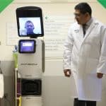 A portrait of Dr. Ivar Mendez standing beside medical equipment.