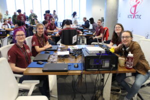 Students sitting at a rounch table working on computers.